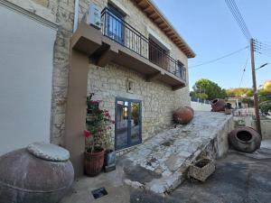 a stone building with a balcony and flowers on it at Estia Mylona in Ayios Therapon