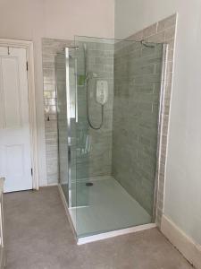 a shower with a glass enclosure in a bathroom at Watercombe House in Wheddon Cross