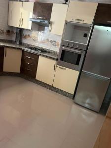 a kitchen with a stainless steel stove and refrigerator at Appartement proche toutes commodités in Berkane