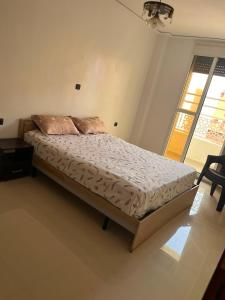 a large bed in a bedroom with a window at Appartement proche toutes commodités in Berkane