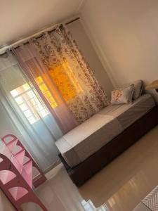 a bed in a room with a window and a curtain at Appartement proche toutes commodités in Berkane