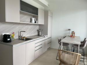 a kitchen with a sink and a table with chairs at Rea's Luxury Suite Gialova in Gialova