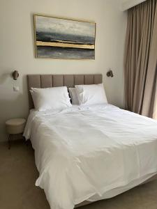 a white bed with white sheets and pillows at Rea's Luxury Suite Gialova in Gialova