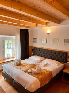 a large bed in a bedroom with wooden ceilings at Hotel La Meridiana in Madesimo