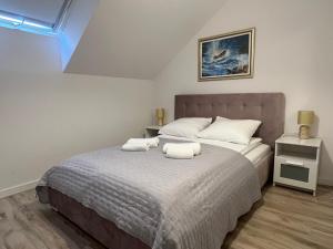 a bedroom with a bed with two towels on it at Apartamenty Mielenko Wichrowe Wzgórze in Mielno