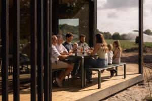 a group of people sitting at a table with wine glasses at Eco by Nature - De Adem - in Heythuysen