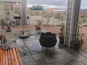 an outdoor patio with a grill and potted plants at Nouvelle Vie Self-catering Accommodation in Reebok