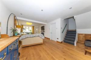 a kitchen and living room with a couch and a staircase at Entire 3 bedroom house in Luton