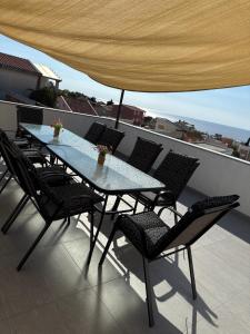 a table and chairs on a balcony with an umbrella at Kevin-Talisa Villa in Bar