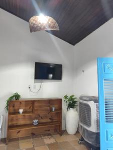 a living room with a tv and a wooden dresser at Dunas House in Luis Correia