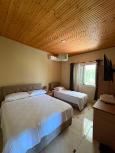 a bedroom with two beds and a wooden ceiling at Mountain House Përmet 