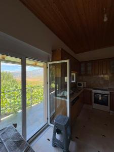 a kitchen with sliding glass doors and a balcony at Mountain House Përmet 