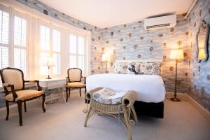 a bedroom with a large bed with a wall covered in rocks at Bass Cottage & Ullikana in Bar Harbor