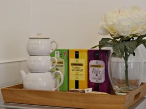 a shelf with a vase and a flower and books at Falkirk Apartments Queen Street in Falkirk +2 photos