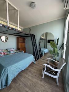 a bedroom with a bunk bed and a chair at Les Terrasses, charme et authenticité en Hyper Centre de TOULON, Idéal pour un séjour romantique ou une escapade urbaine in Toulon