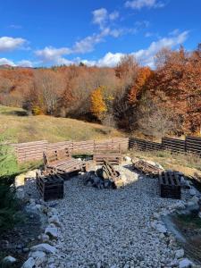 a group of wooden benches on a rocky ground at RanyA-Frame in Nucşoara