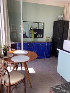 a kitchen with a table and blue cabinets at Les Terrasses, charme et authenticité en Hyper Centre de TOULON, Idéal pour un séjour romantique ou une escapade urbaine in Toulon +31 photos