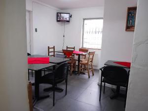 a dining room with tables and chairs and a window at Hotel Don Matías in Concepción