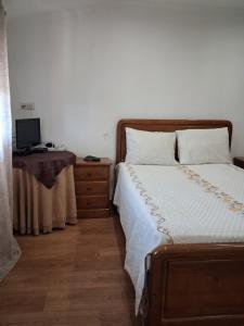 a bedroom with a bed and a desk with a television at Casa dos Ramos in Rio de Fornos