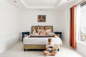 a woman and two children sitting on a bed at Alma by iVAVev in Mamaia +46 photos