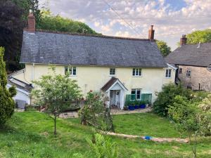a white house with a black roof at Watercombe House in Wheddon Cross