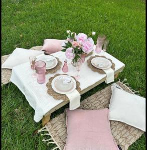 a picnic table with plates and flowers on it at Golden Hour in Cockburn Harbour