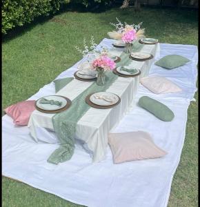 a white table with plates and flowers on it at Golden Hour in Cockburn Harbour