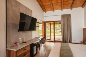 a room with a television on a wall with a desk at Ensenada Hotel y Campo Asociado Casa Andina in Cajamarca