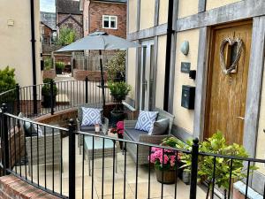 a balcony with an umbrella and a chair and an umbrella at The Stokesay Boutique Townhouse Ludlow in Ludlow