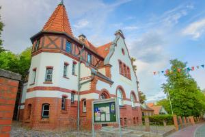a large building with a tower on a street at Hotel Restaurant Nordpol in Heiligenhafen