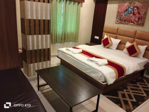 a bedroom with a large bed and a table at Hotel ashtha inn in Gaya