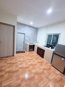 an empty room with a wooden floor and a kitchen at PATTARAWAN House in Thong Sala