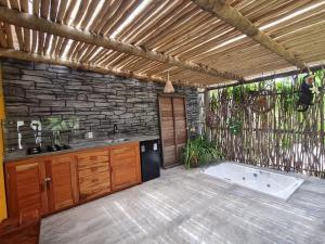 a kitchen with a tub and a stone wall at Chalé Jacuzzi Fortim in Fortim +10 photos