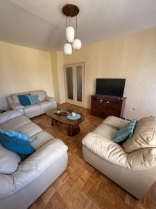 a living room with two couches and a flat screen tv at Sweet dreams apartment in Bar