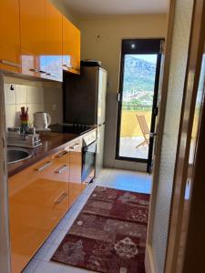 a kitchen with wooden cabinets and a large window at Sweet dreams apartment in Bar