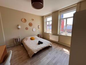 a bedroom with a bed and two windows at Charme et confort - Maison Roubaix 5 chambres in Roubaix