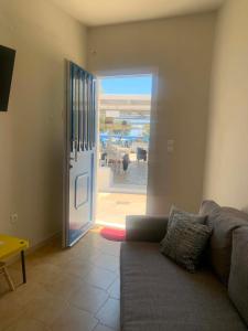 a living room with a couch and a sliding glass door at Blue Door Hideaway in Moutsoúna