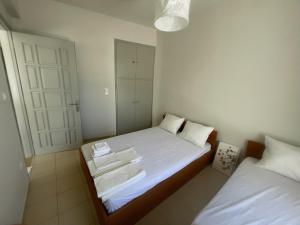 a small bedroom with two beds with white sheets at Blue Door Hideaway in Moutsoúna