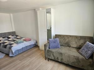 a bedroom with a couch and a bed and a chair at Zakątek przy Wydmie in Dziwnów