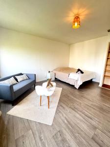 a room with two beds and a couch and a table at Bricks Pérignon - Tram, lit Queen size & air fryer in Chenôve
