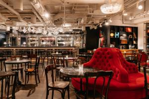 a restaurant with tables and chairs and a red couch at Ruby Lissi Hotel Vienna by IHG in Vienna