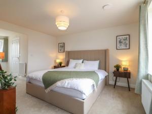 a bedroom with a large bed with white sheets at Stepping Stone in Ashbourne
