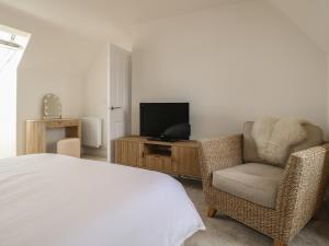 a bedroom with a bed and a chair and a television at Stepping Stone in Ashbourne