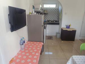a kitchen with a refrigerator and a table with water bottles on it at First floor apartment with view and balcony and with charming pool near sandy beach and commerces in Pointe aux Biches