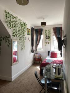 a bedroom with a bed and a chair and a mirror at The Palms Guest house in Torquay