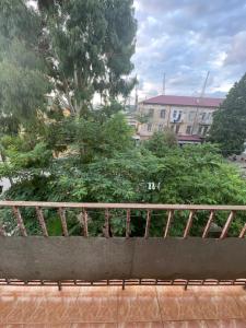 a balcony with a wooden railing and some bushes at Poti apartment in Poti