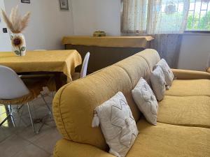 a living room with two yellow couches and a table at Giardino di Chiara al mare in Torre Rinalda +41 photos
