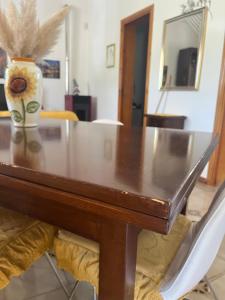 a dining room table with a vase on top of it at Giardino di Chiara al mare in Torre Rinalda