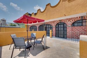 un tavolo, sedie e un ombrellone su un patio di Stylish & Spacious Unit w/ Deck in Cuernavaca a Cuernavaca