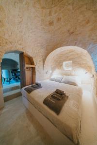ein Schlafzimmer mit einem großen Bett in einer Steinwand in der Unterkunft Trullo Cervillo in Cisternino